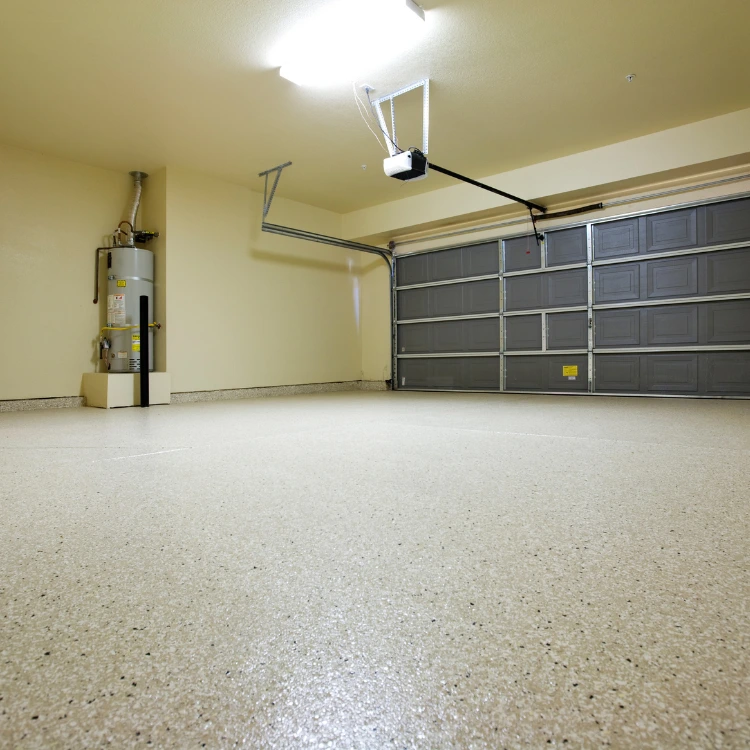 Clean, empty residential garage with a grey sectional garage door, overhead opener