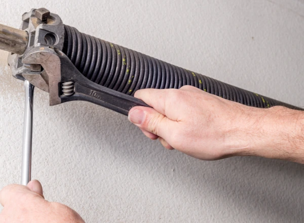 DYG Garage Doors specialist performing maintenance on a garage door spring