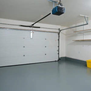 Garage interior with a closed white sectional garage door, a blue overhead automatic opener