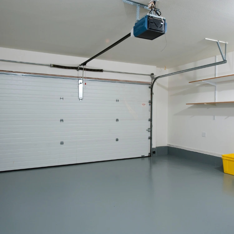 Garage interior with a closed white sectional garage door, a blue overhead automatic opener
